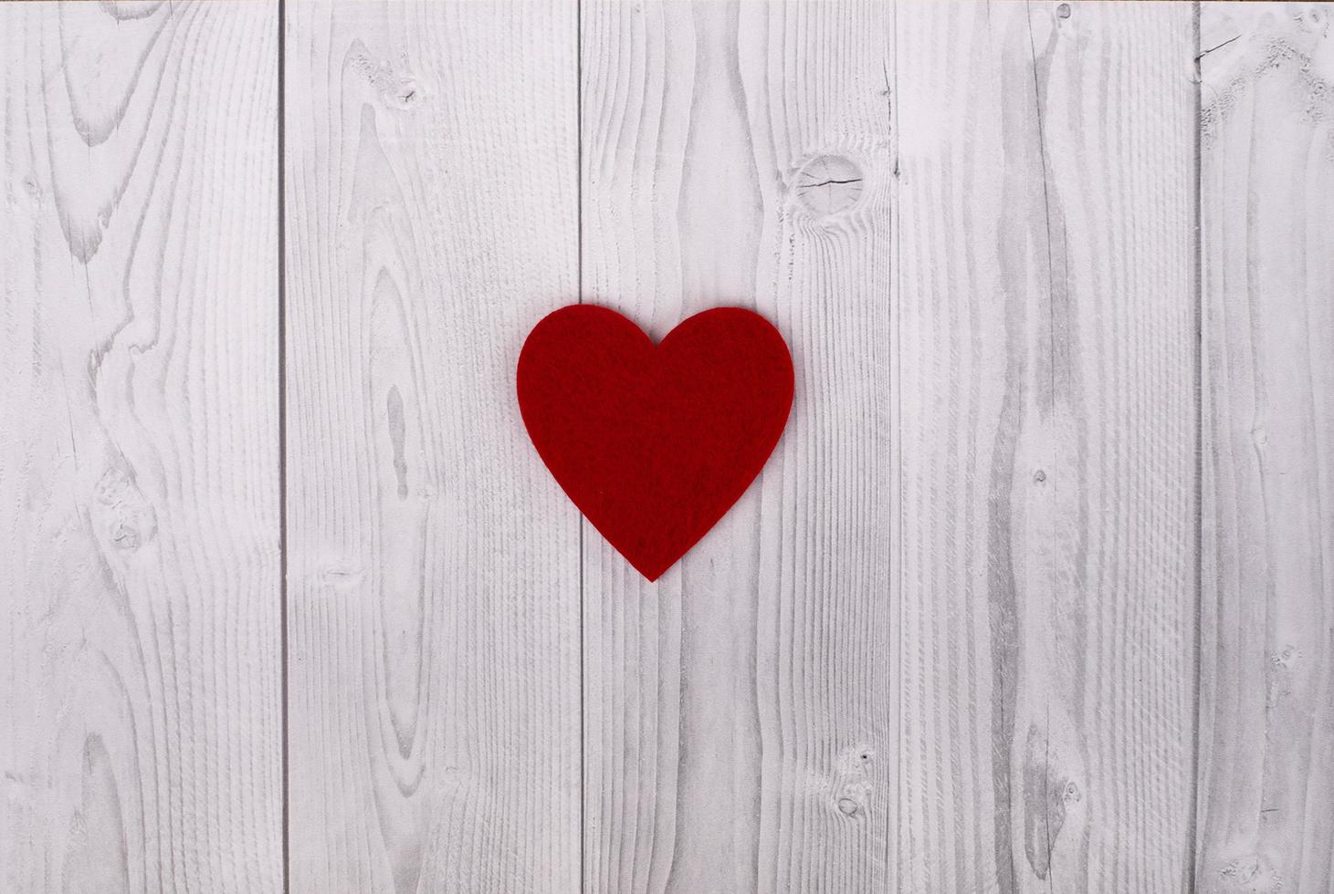 rött hjärta på en grå och vit träbakgrund. Alla hjärtans dag koncept foto