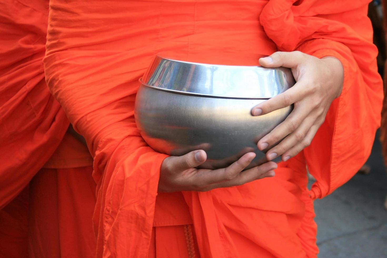 munk som håller silverskål foto