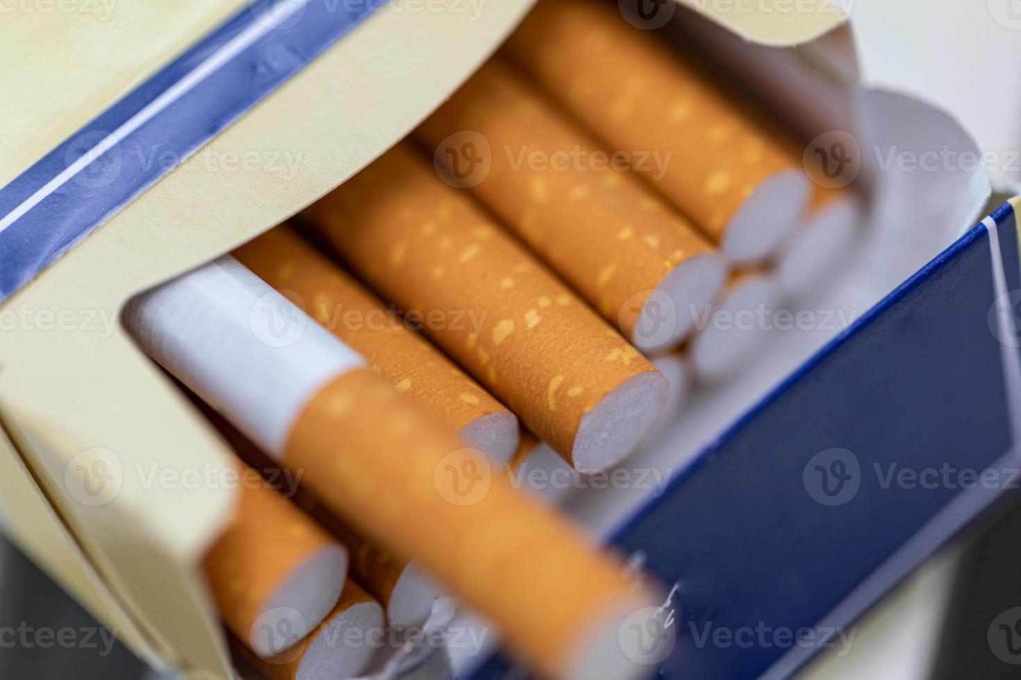 cigaretter stänga upp. cigaretter i en packa. gul filtrera. skada till hälsa. dålig vana. en packa av cigaretter på de tabell. öppen packa av cigaretter. foto