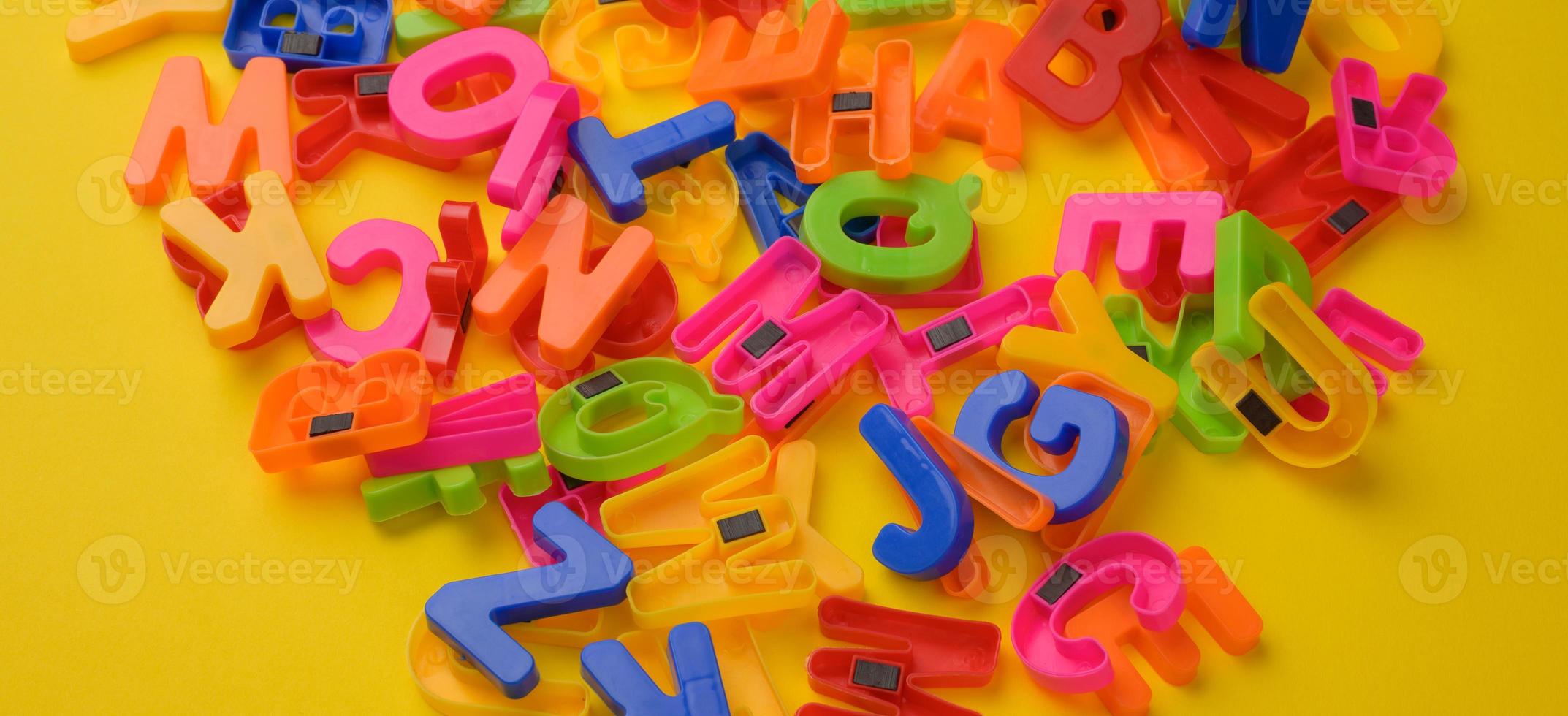 flerfärgad plast engelsk alfabet brev med magnet på gul bakgrund foto