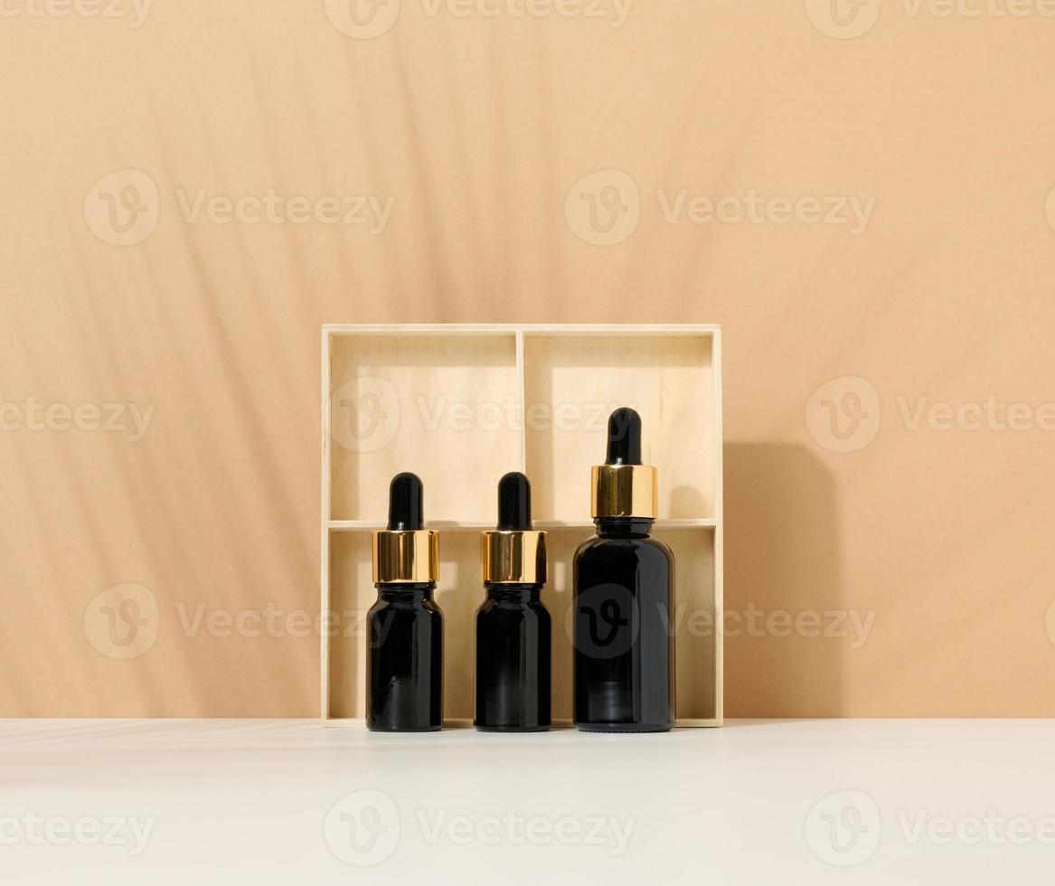 glas brun flaska med pipett en på ljus brun bakgrund. attrapp hudvård kosmetisk produkt foto