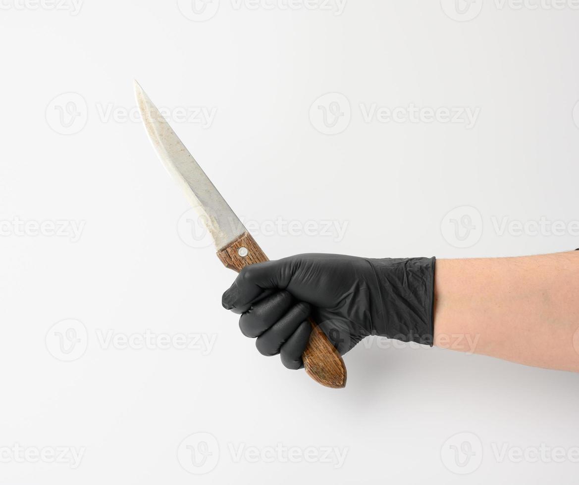 hand i en svart latex handske innehar en kök kniv på en vit bakgrund foto