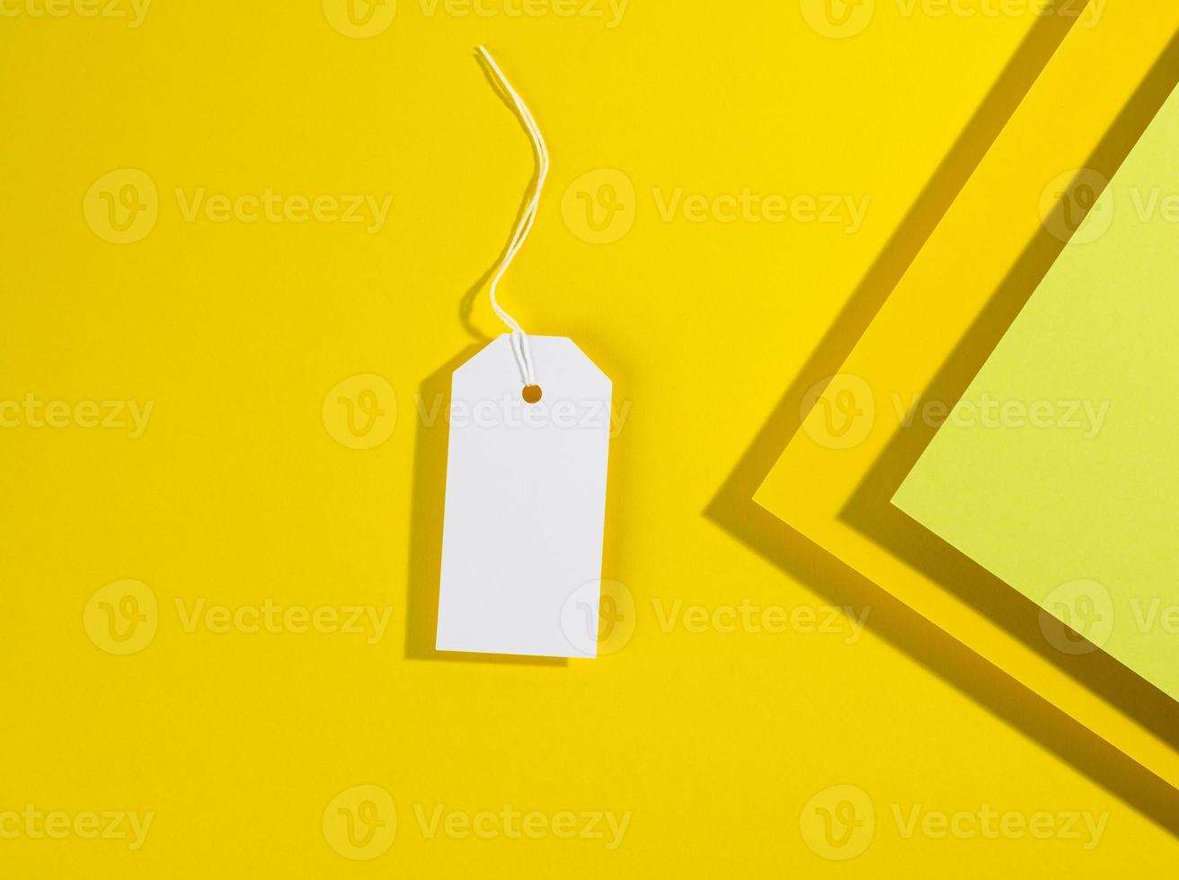 tom rektangulär papper gul pris märka med vit rep på gul bakgrund foto