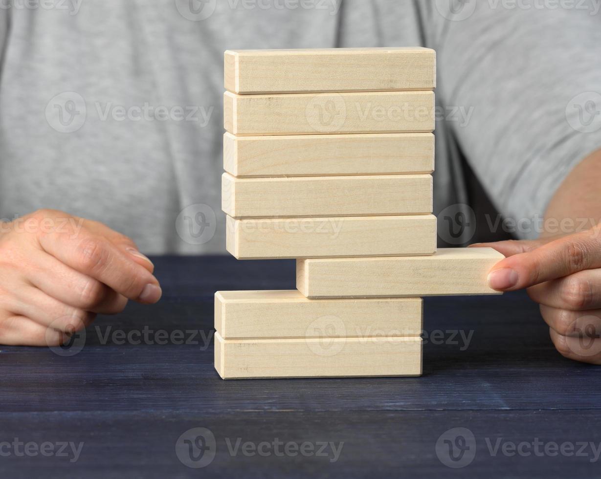 hand drar en trä- blockera ut av de lugg. balans begrepp, situation kontrollera foto