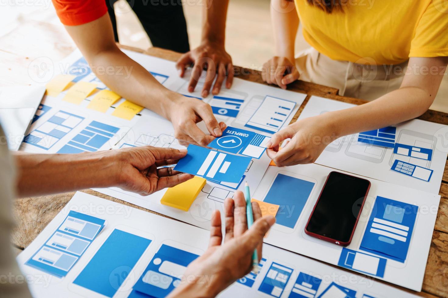 ux utvecklare och ui designer brainstorming handla om mobil app gränssnitt trådmodell design med kund kortfattat och Färg koda på modern kontor. foto