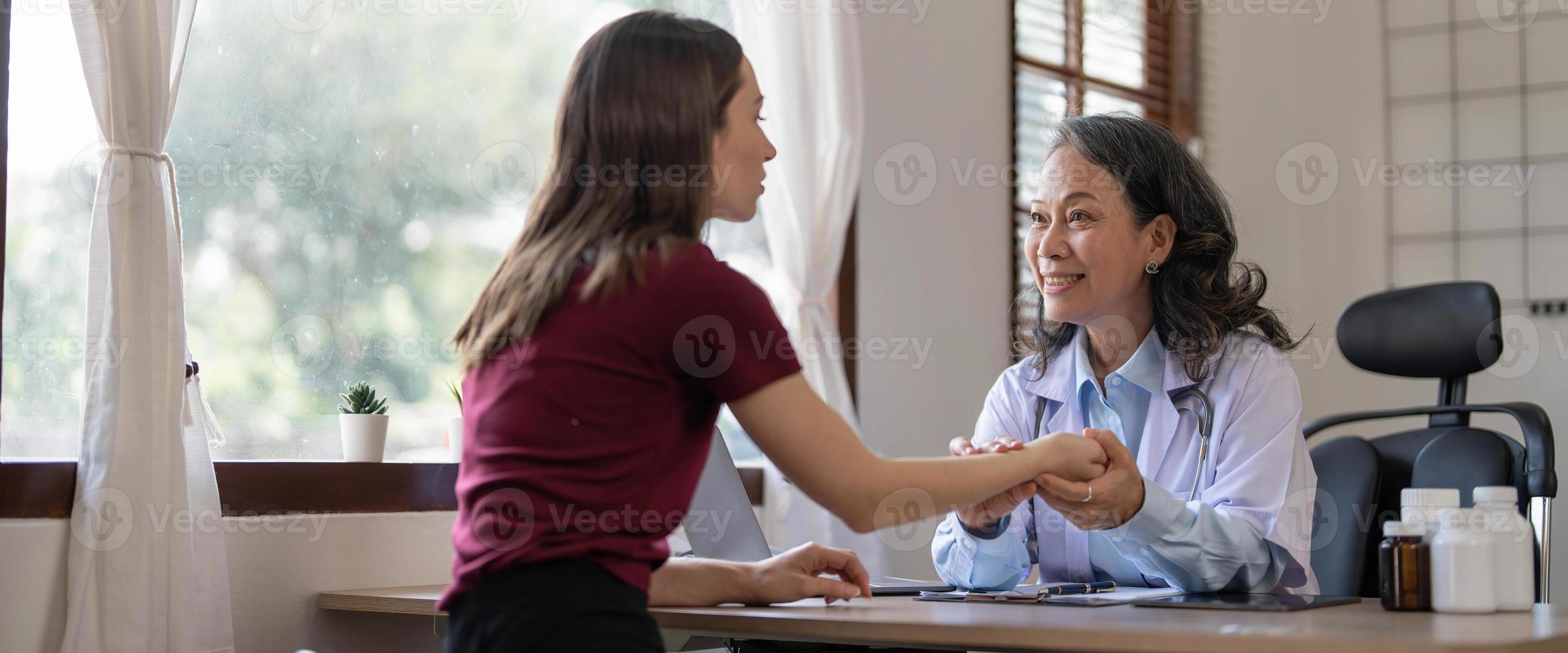 mitten åldrig kvinna barnläkare lyssnande till ung kvinnas klagomål med hälsa problem och skriva ner på de medicinsk historia papper under de behandling. hälsa begrepp foto