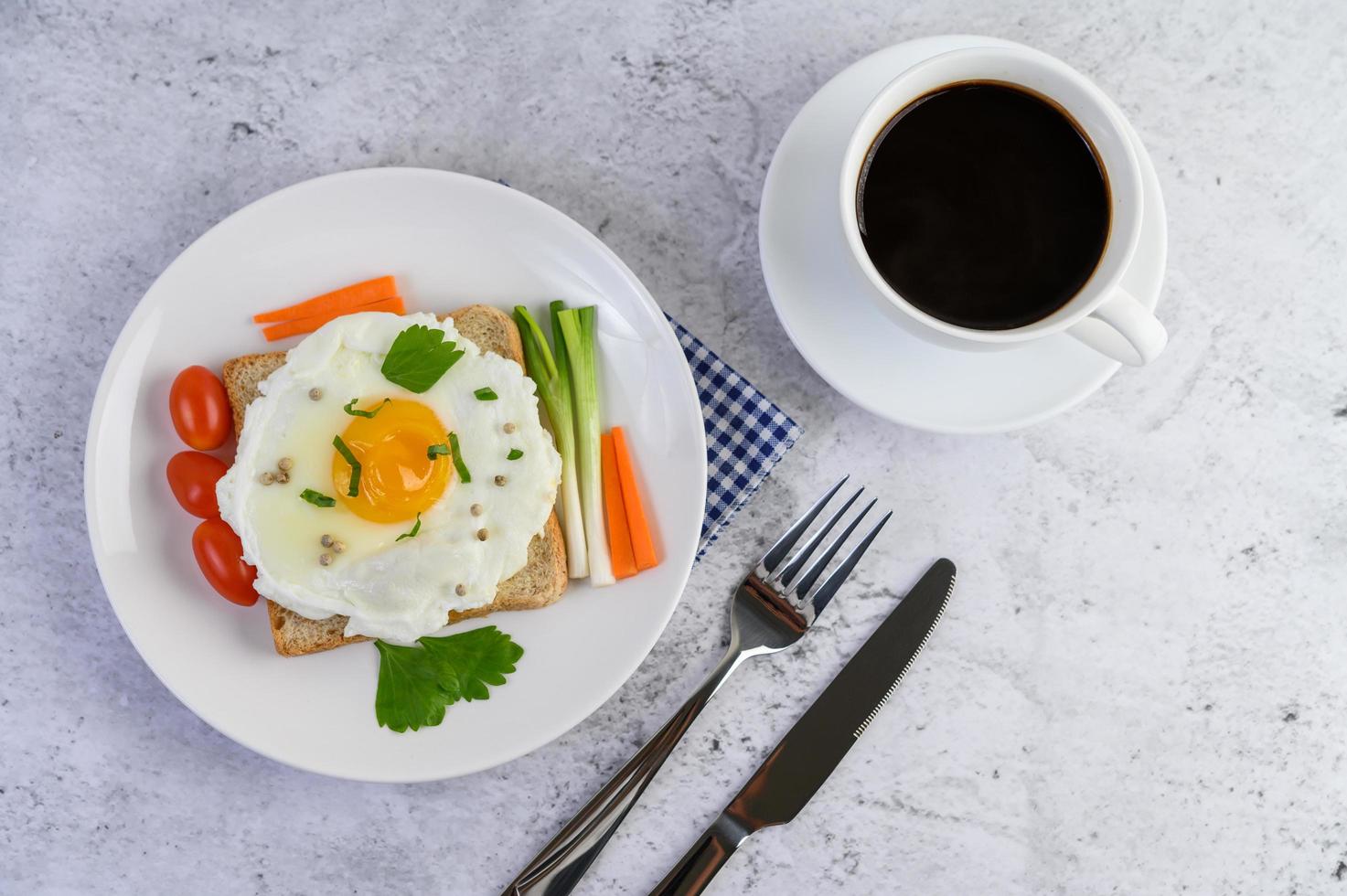 ett stekt ägg på toast toppat med pepparkärnor med morötter och vårlök foto