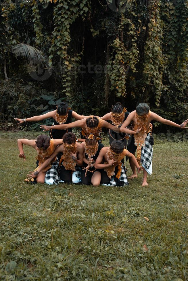 en knippa av asiatisk människor har roligt medan tar en Foto skjuta med en gyllene dansa kostym i främre av de djungel