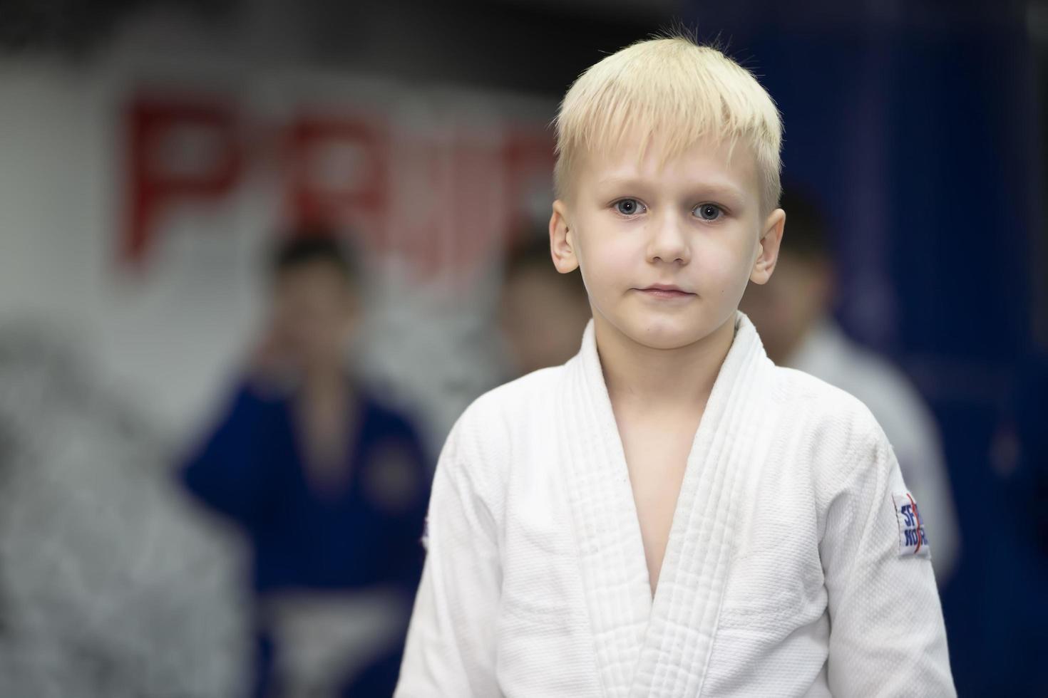 belarus, stad av gomil, december 15, 2021. judo skola för barn. porträtt av en liten judoka pojke ser på de kamera. foto