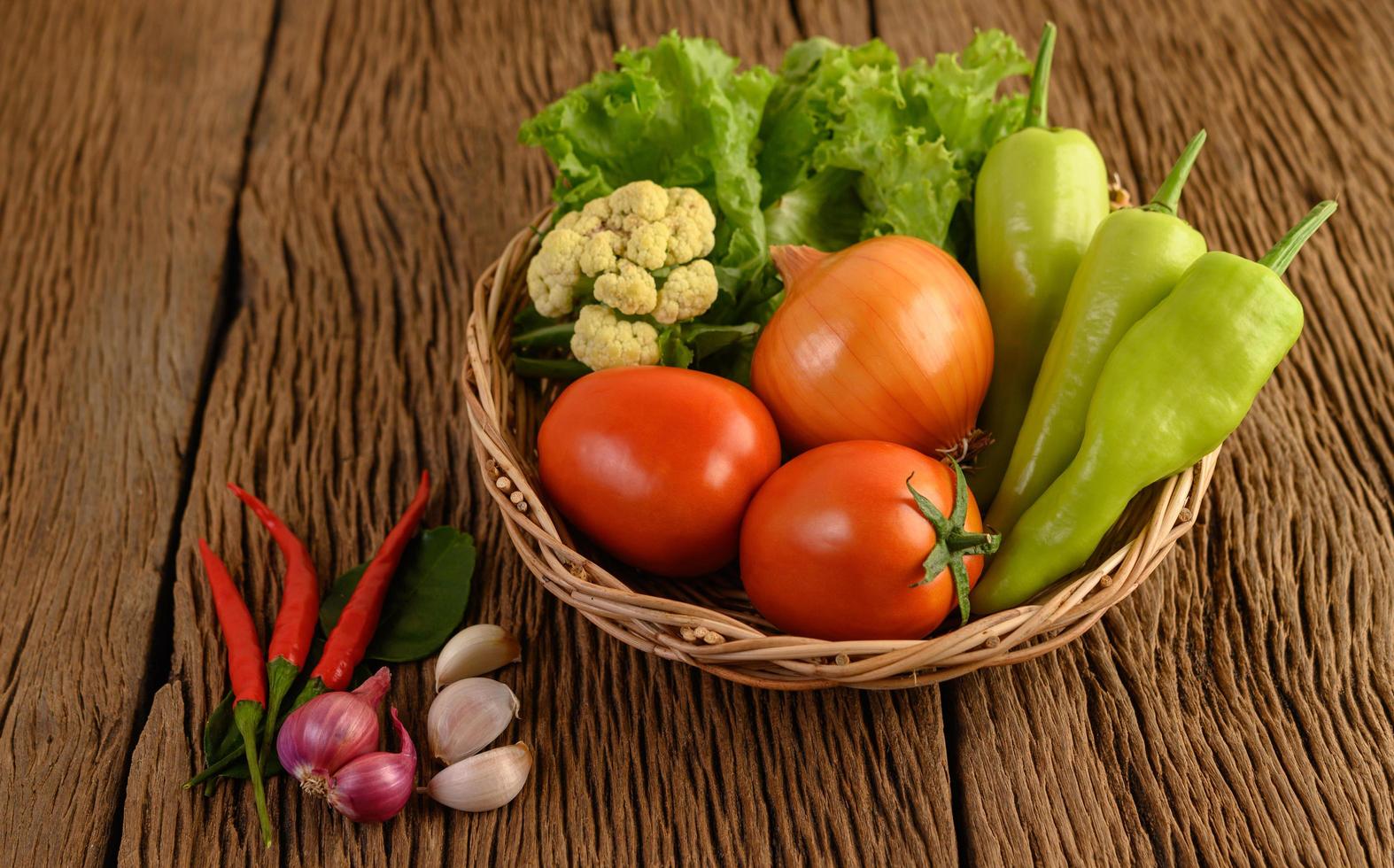 paprika, tomat, lök, sallad, chili, schalottenlök, vitlök, blomkål och kaffelimeblad foto