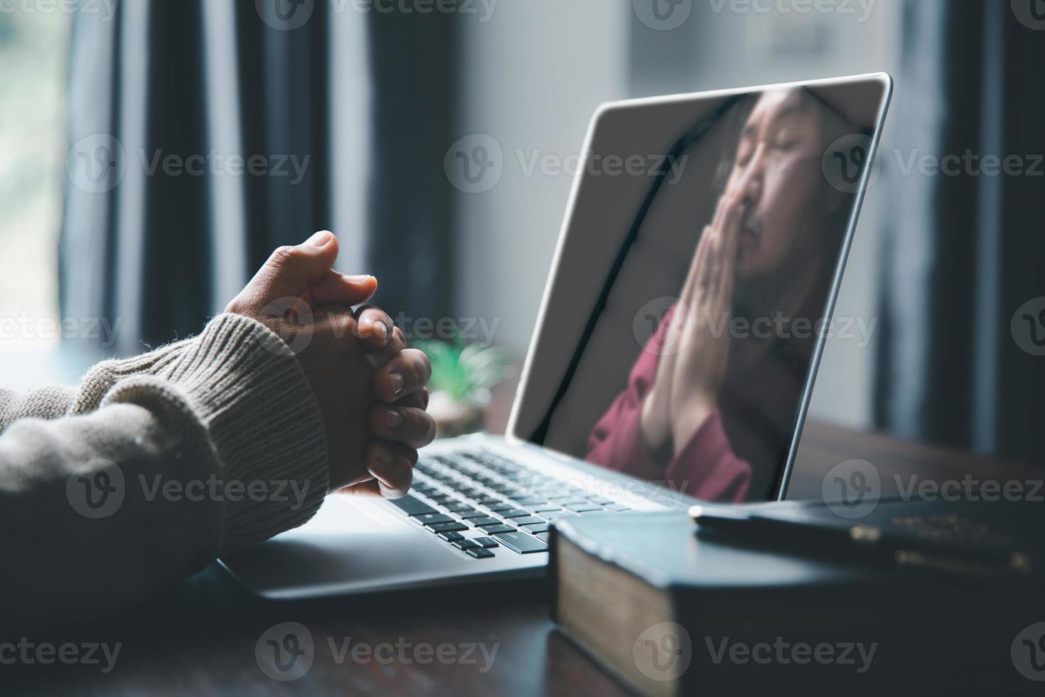 kristen uppkopplad teknologi begrepp. händer bön- av kristen med digital dator bärbar dator, uppkopplad leva kyrka för söndag service. asiatisk katolik kvinna är läsning helig bibel bok och uppkopplad studie. foto