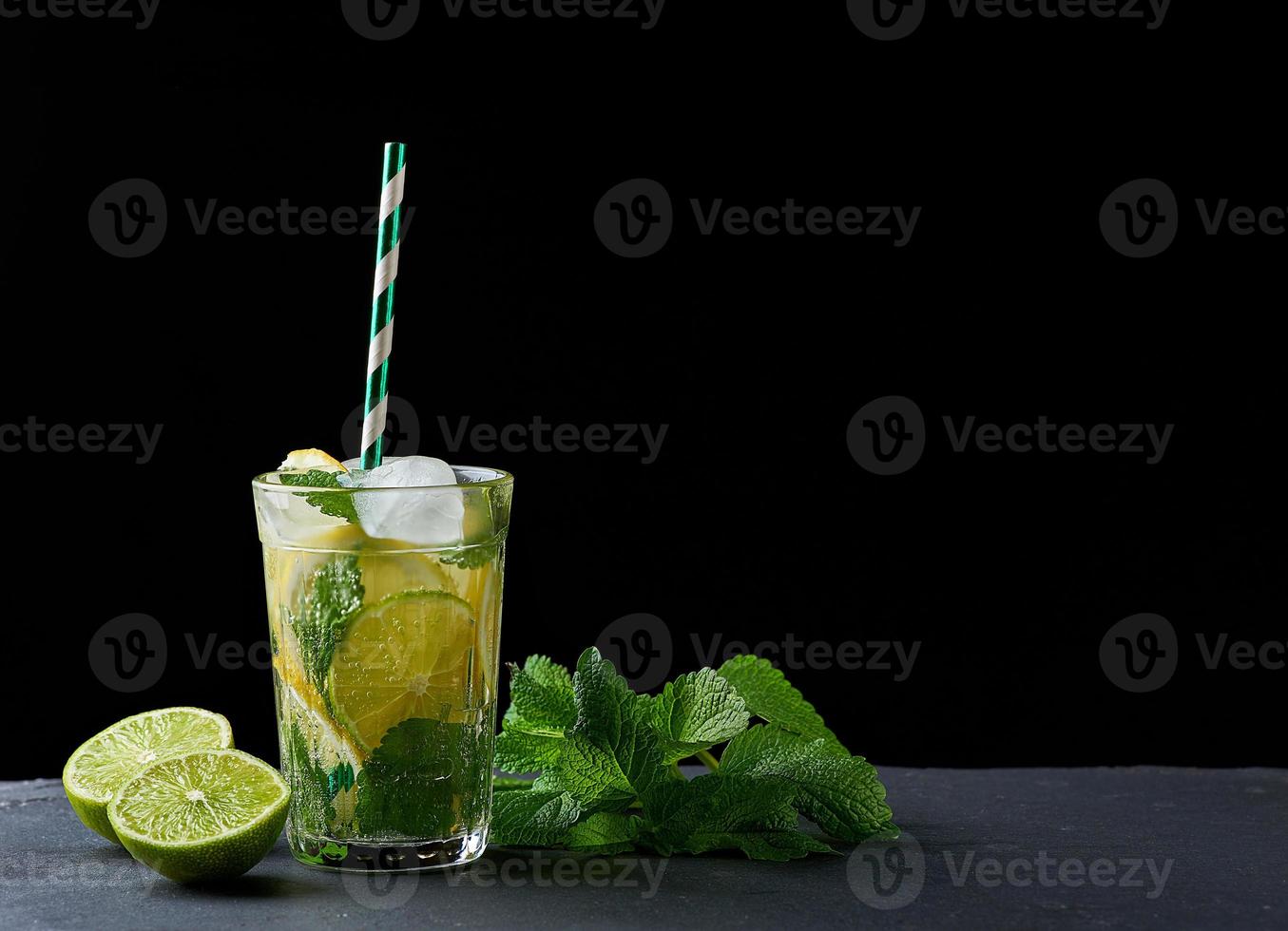 sommar uppfriskande dryck citronsaft med citroner, mynta löv, is kuber och kalk i en glas foto
