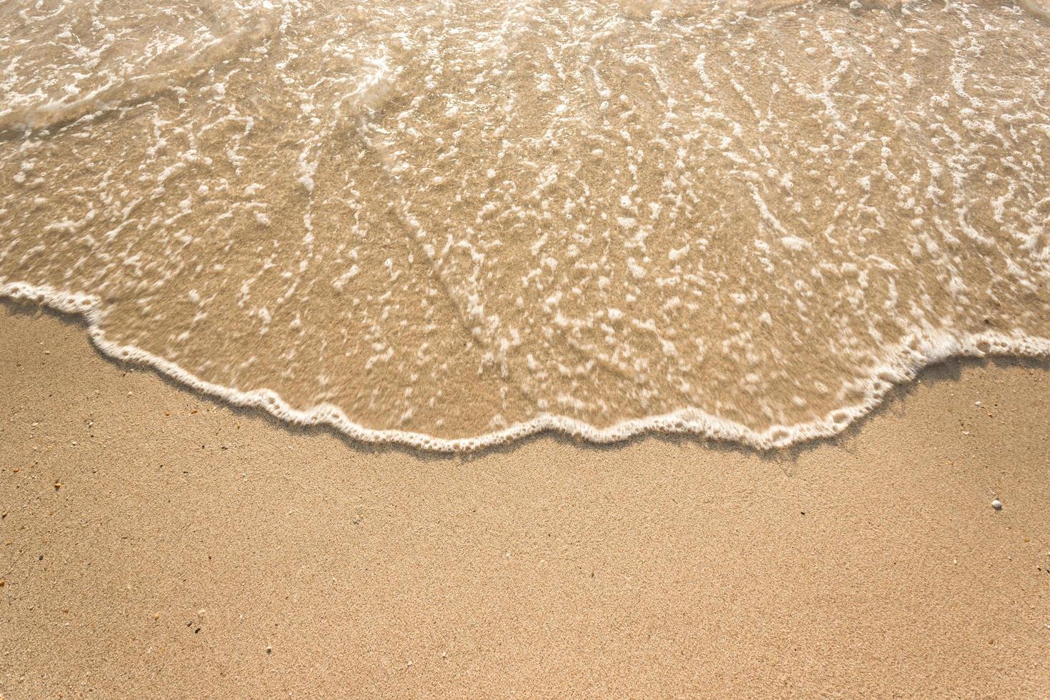 havsvågor på sandstrand foto