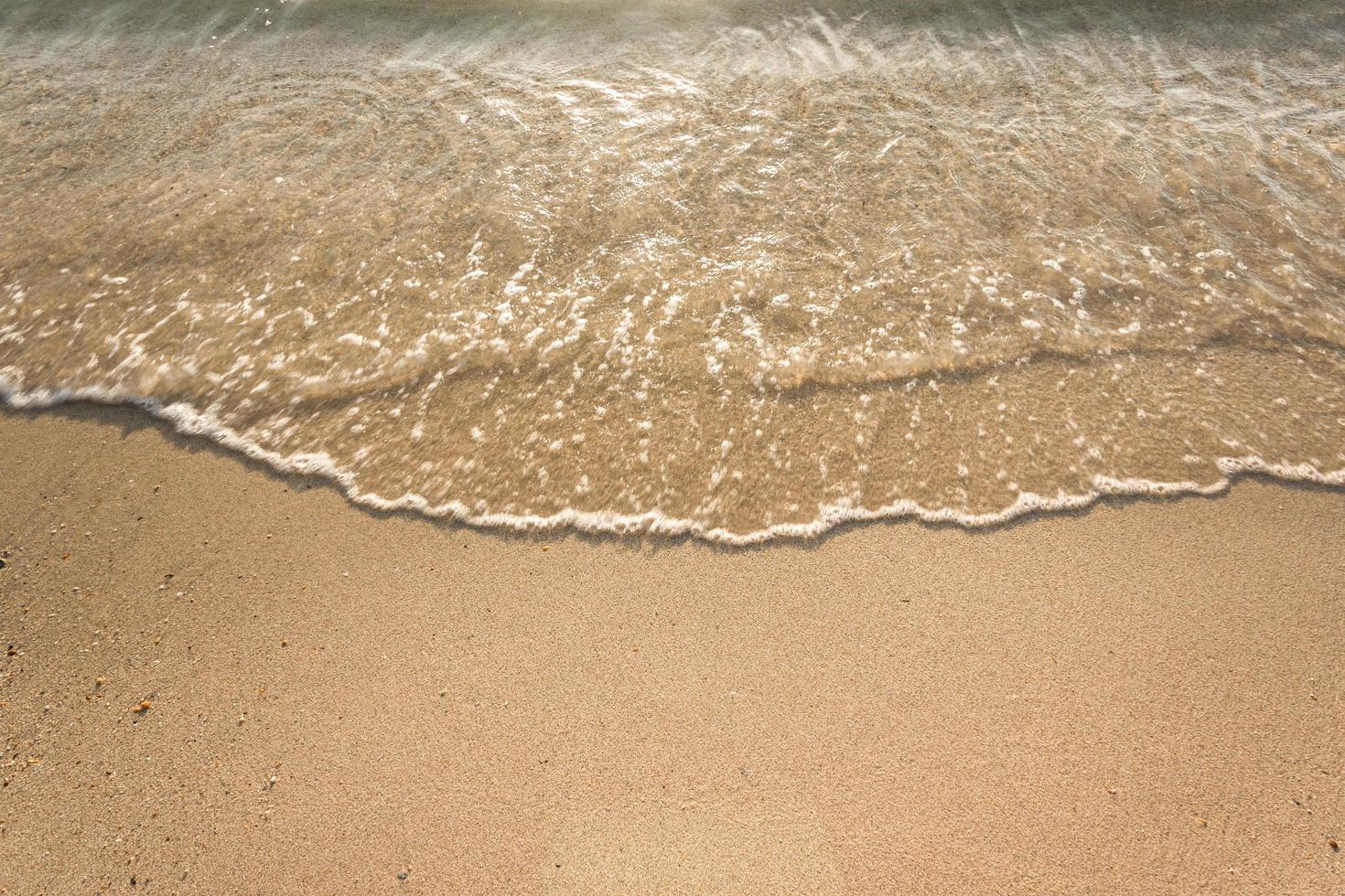 havsvågor på sandstrand foto