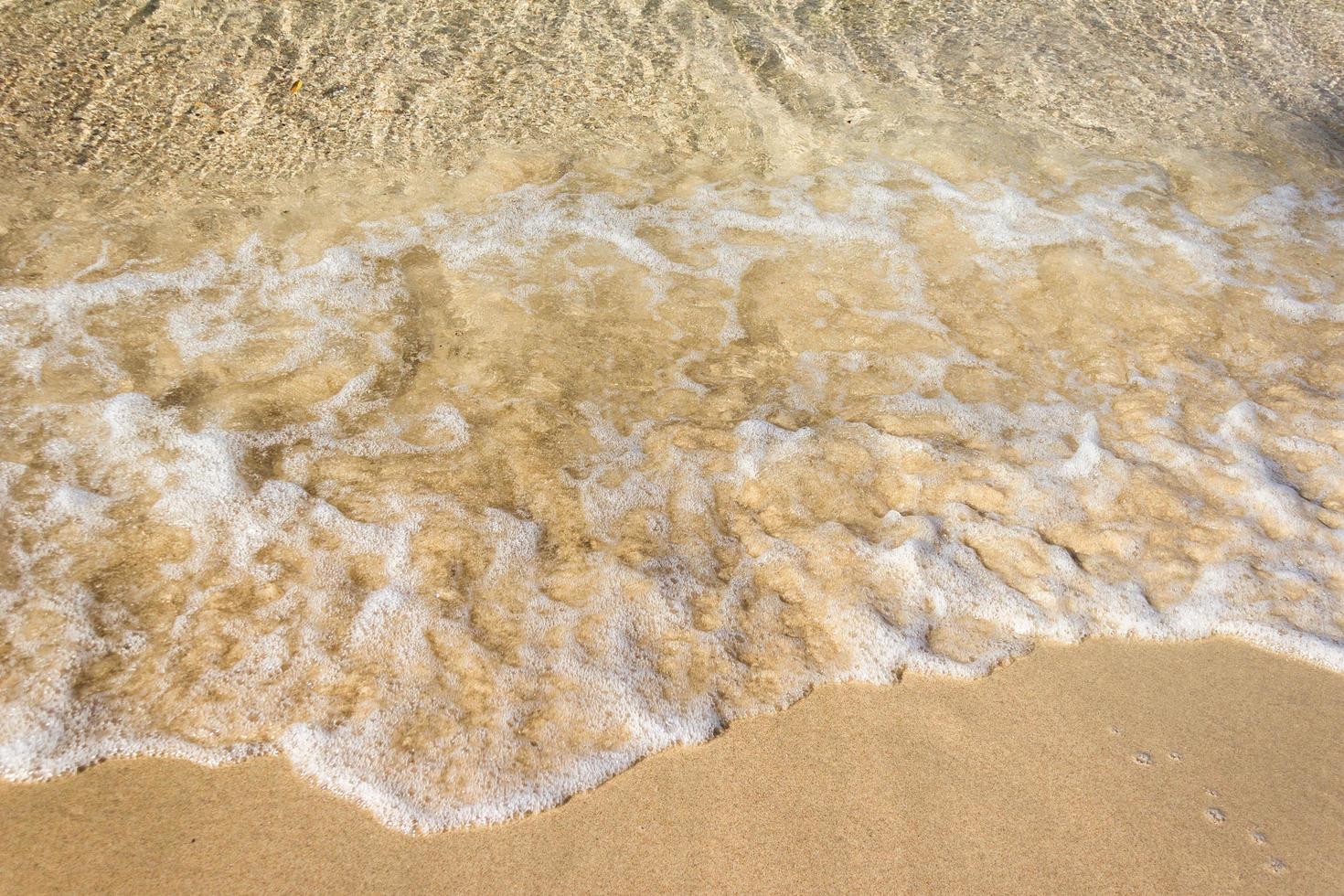 havsvågor på sandstrand foto