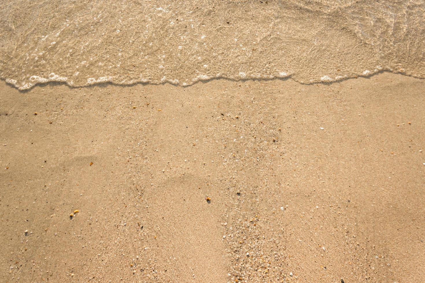 havsvågor på sandstrand foto