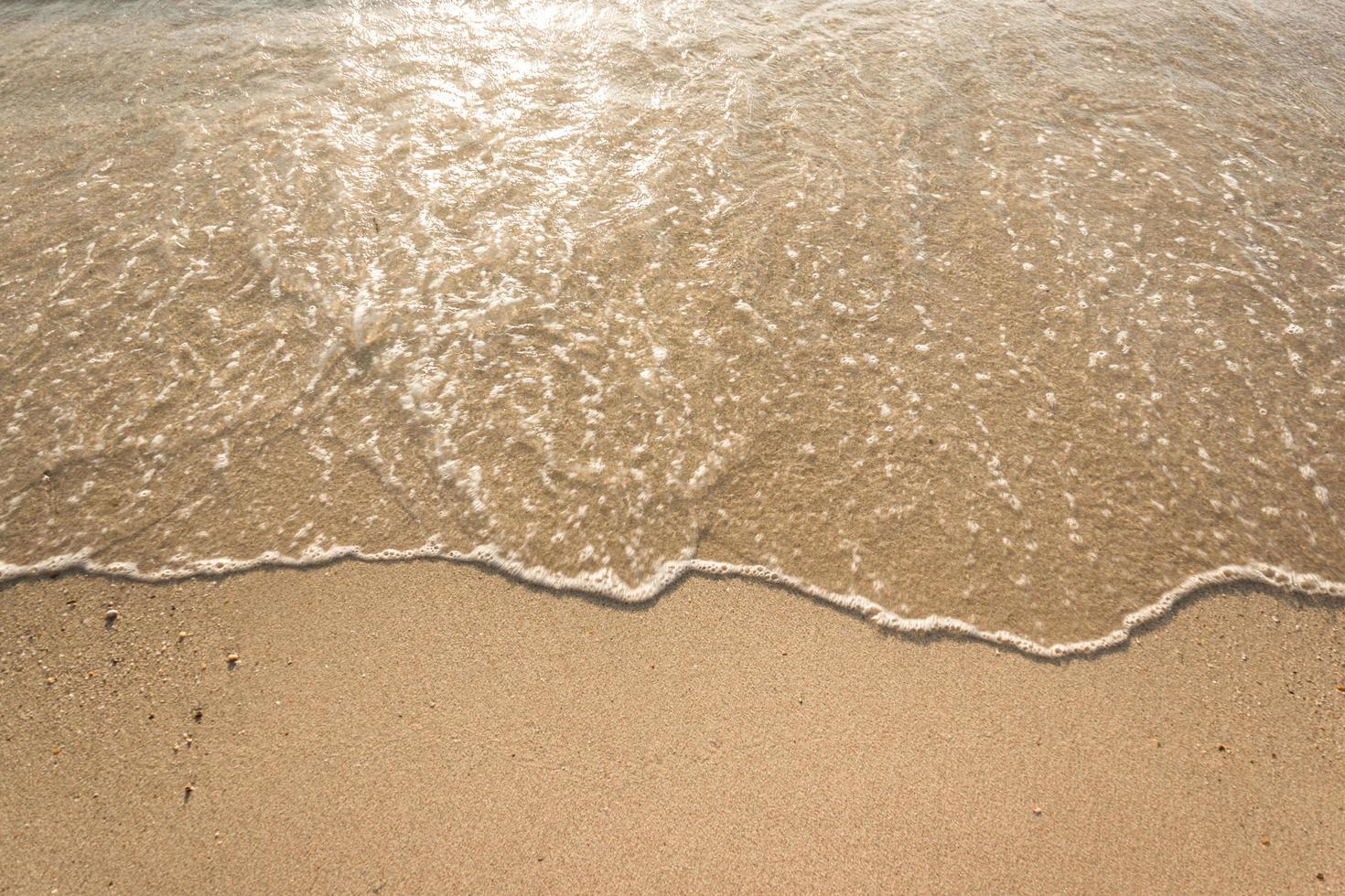 havsvågor på sandstrand foto