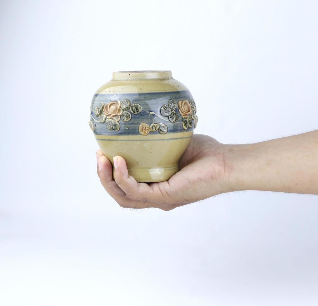 hand innehav årgång keramisk vas isolerat på en vit bakgrund foto