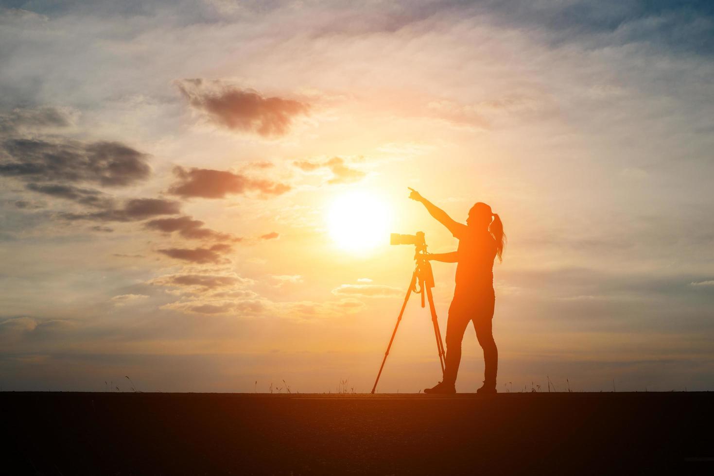 silhuett av en fotograf som skjuter vid solnedgången foto