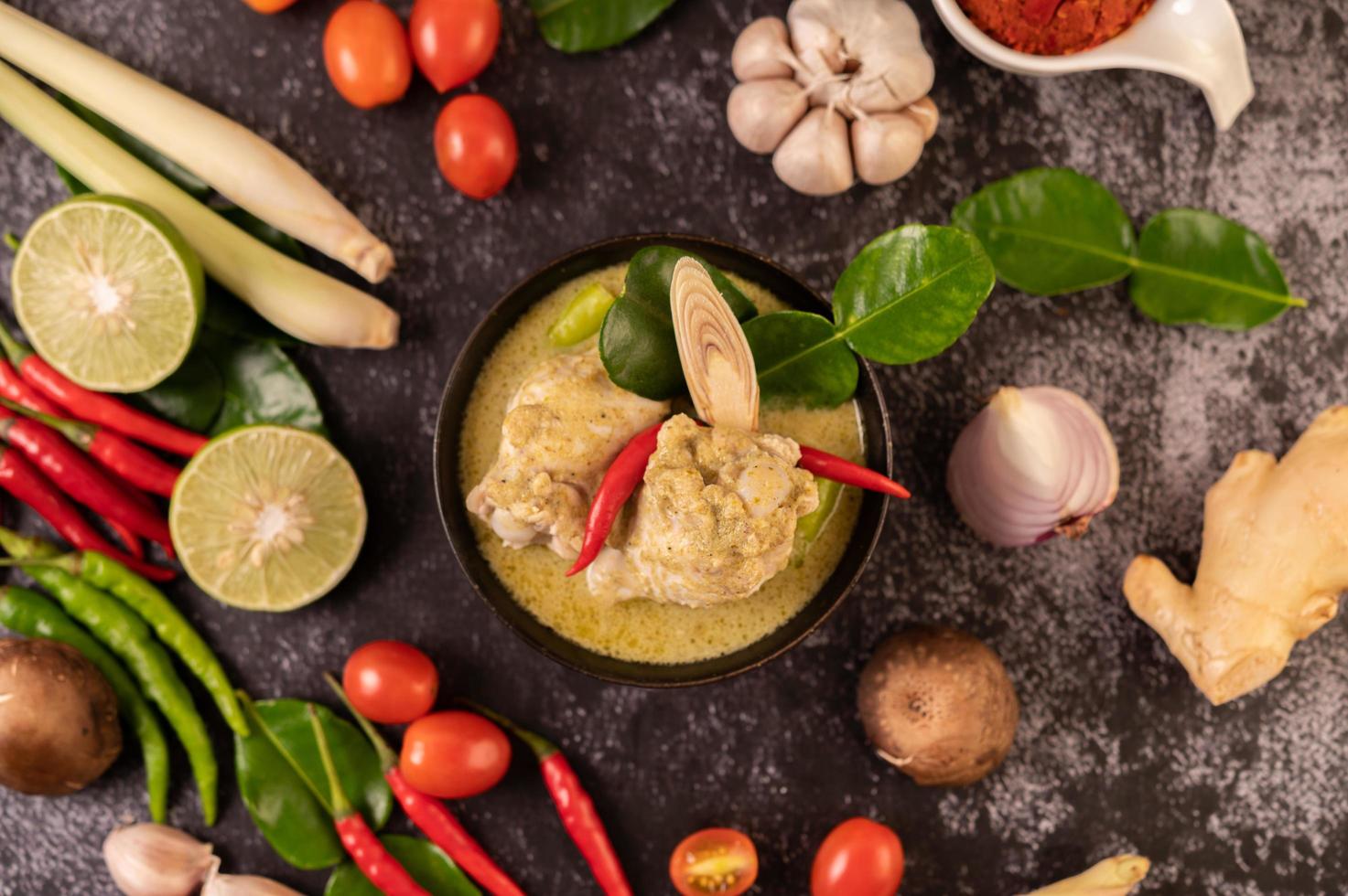grön curryrätt med kyckling, chili och basilika och tomat och lime foto