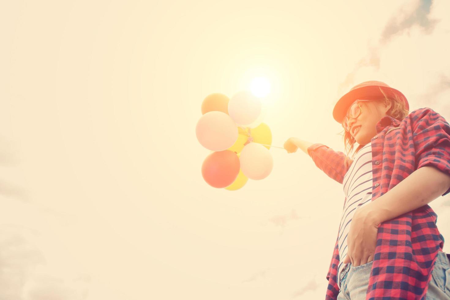 ung hipster kvinna med ballonger under himlen foto