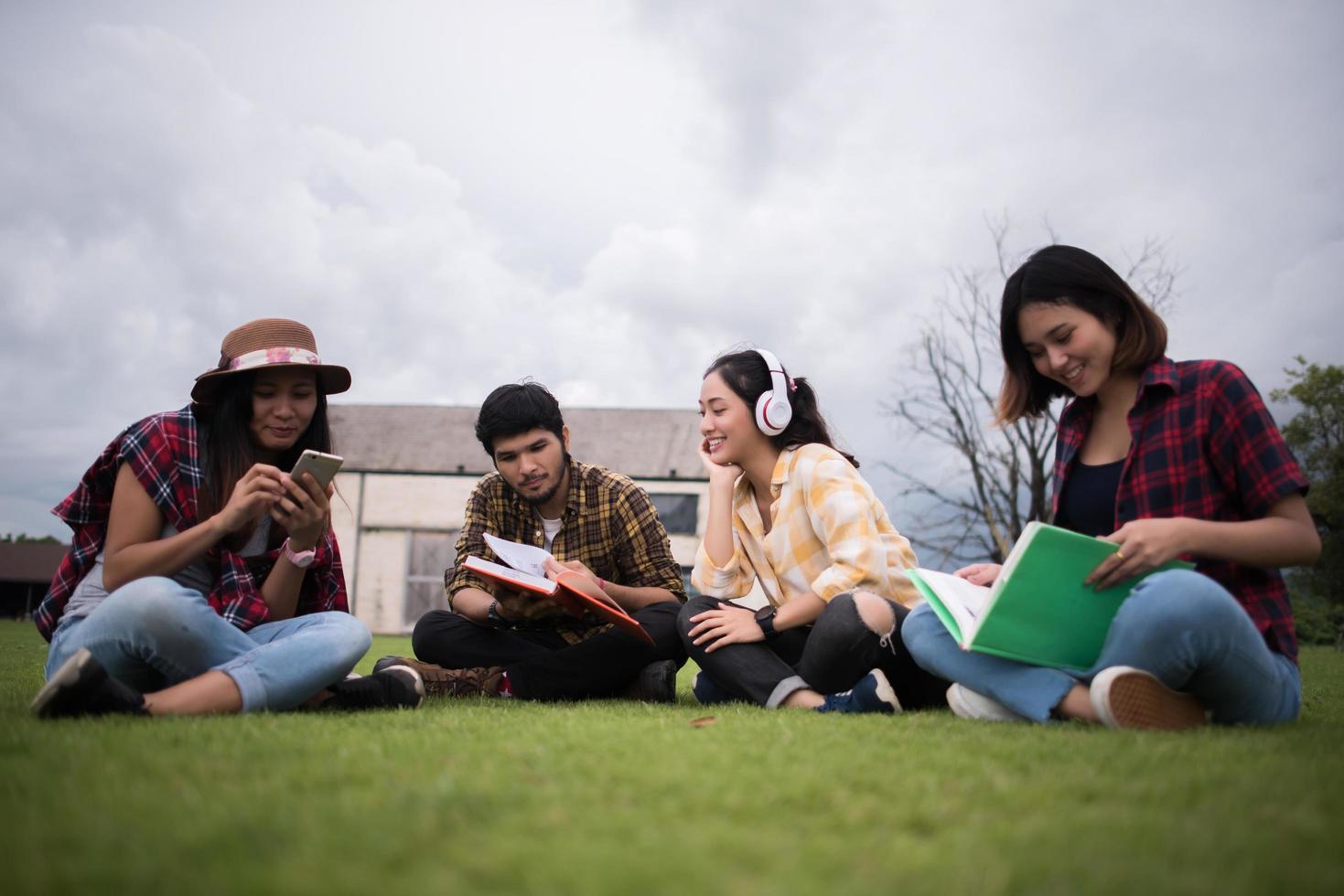 grupp studenter som sitter i en park efter klassen foto