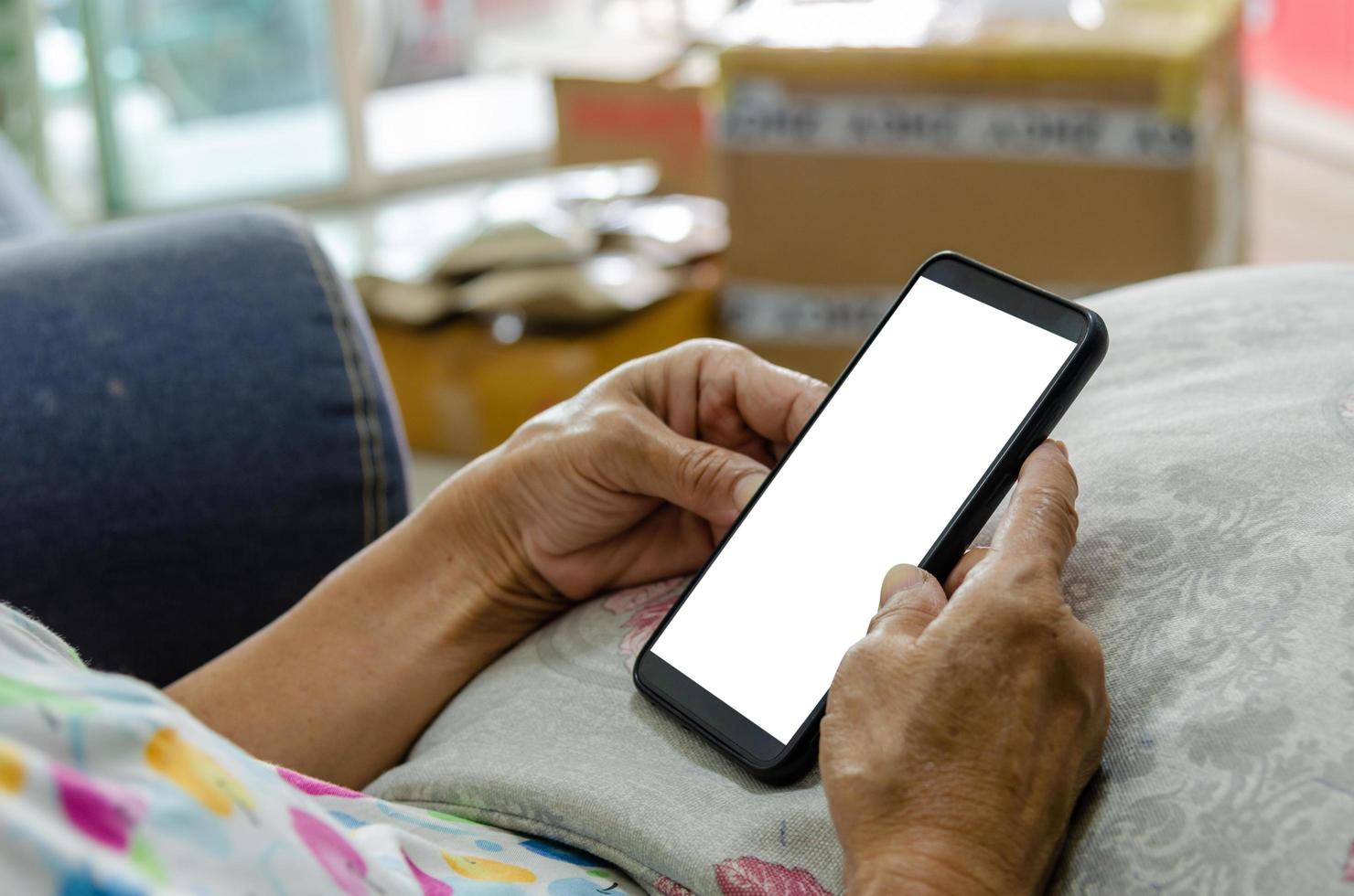 gammal persons händer som håller en smart telefon foto