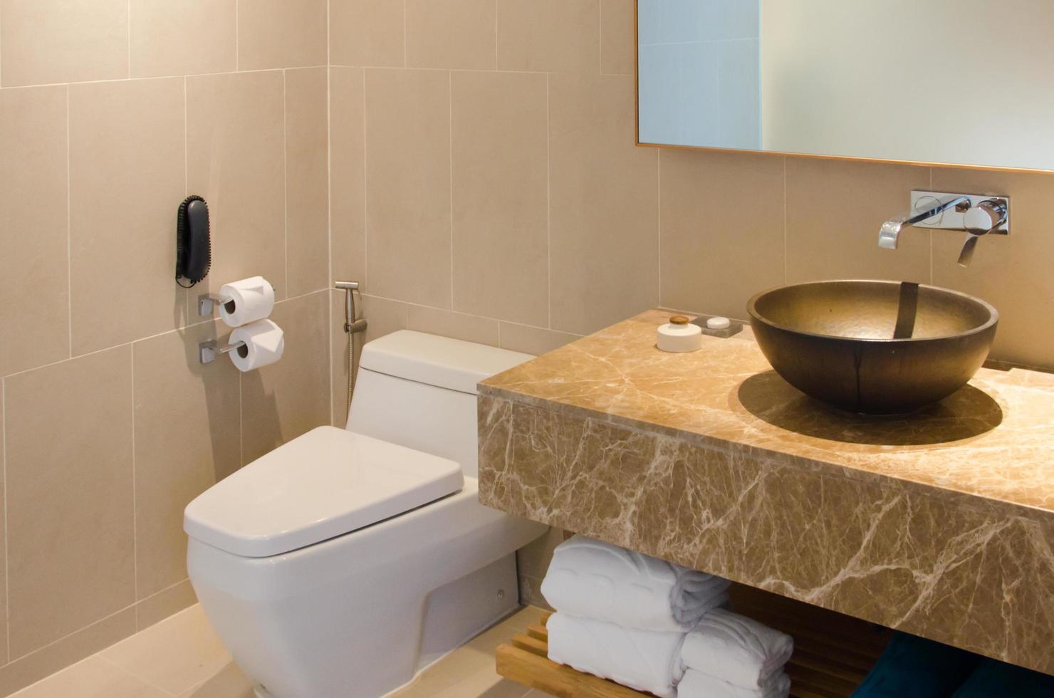 handfat och toalettskål i ett hotellbadrum foto