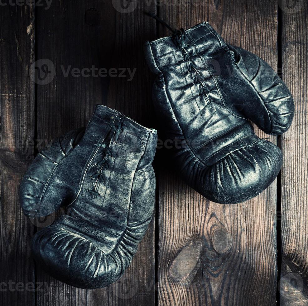 par av svart läder mycket gammal boxning handskar foto