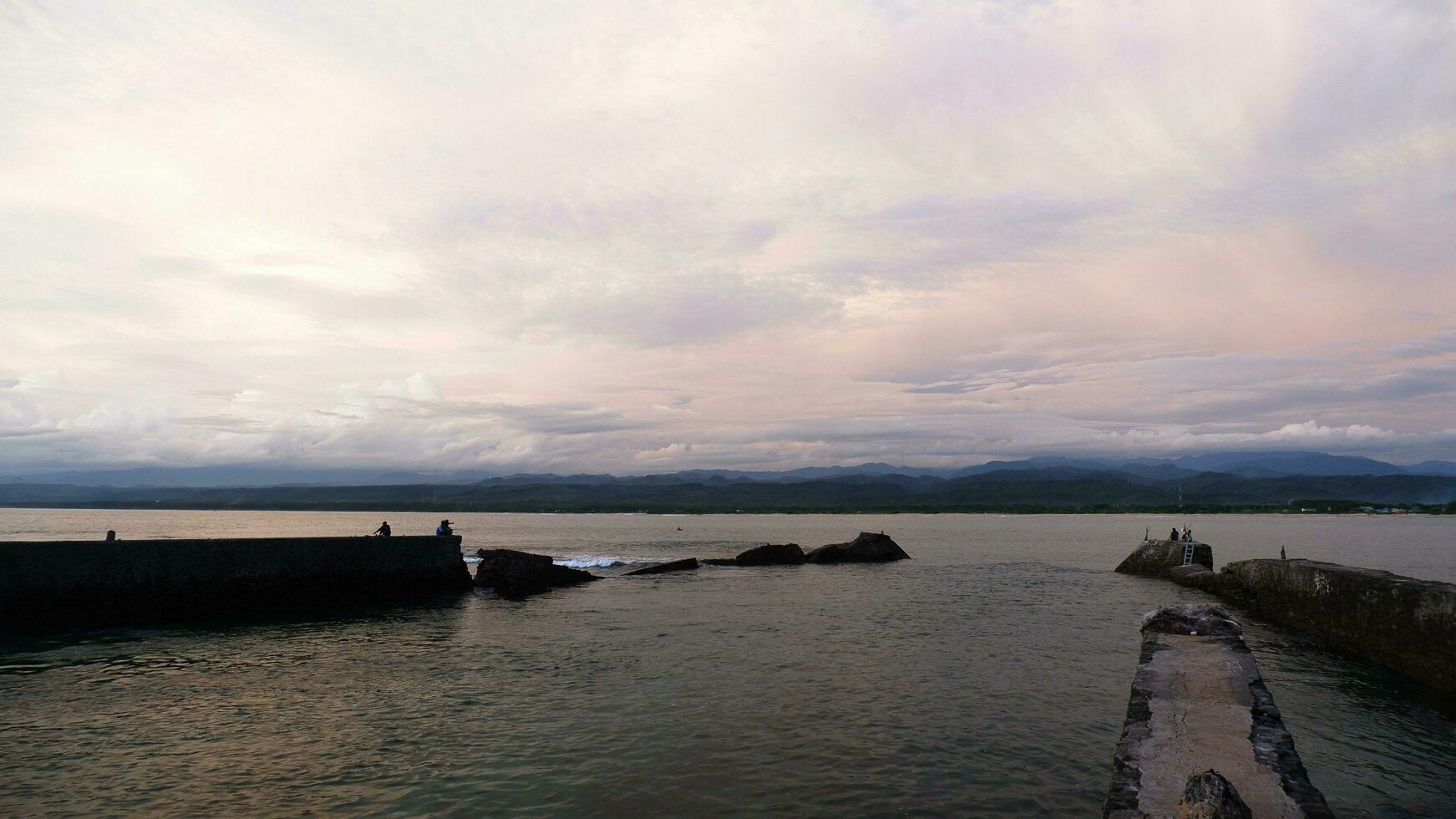 eftermiddag hav se och sjövägg, strand, och korall, solnedgång bakgrund på santolo strand indonesien foto