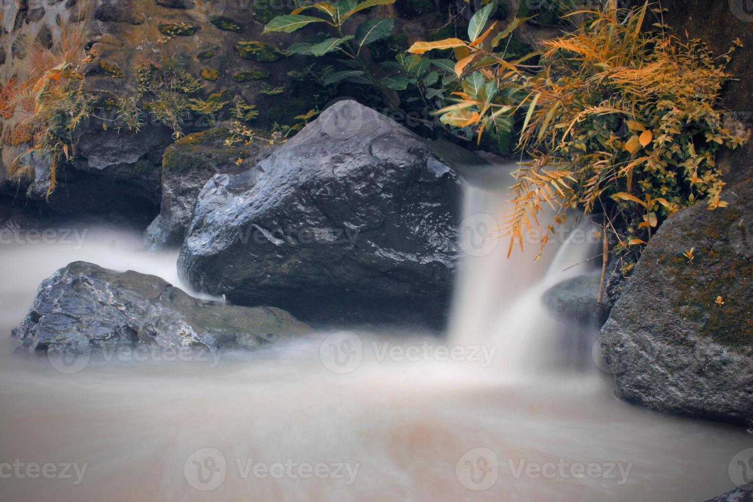 detta är en skön Foto av en ström av vatten strömmande i en flod i de by område.