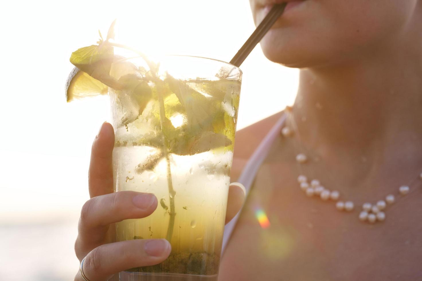 kvinna njuter av en tropisk mojito cocktail foto