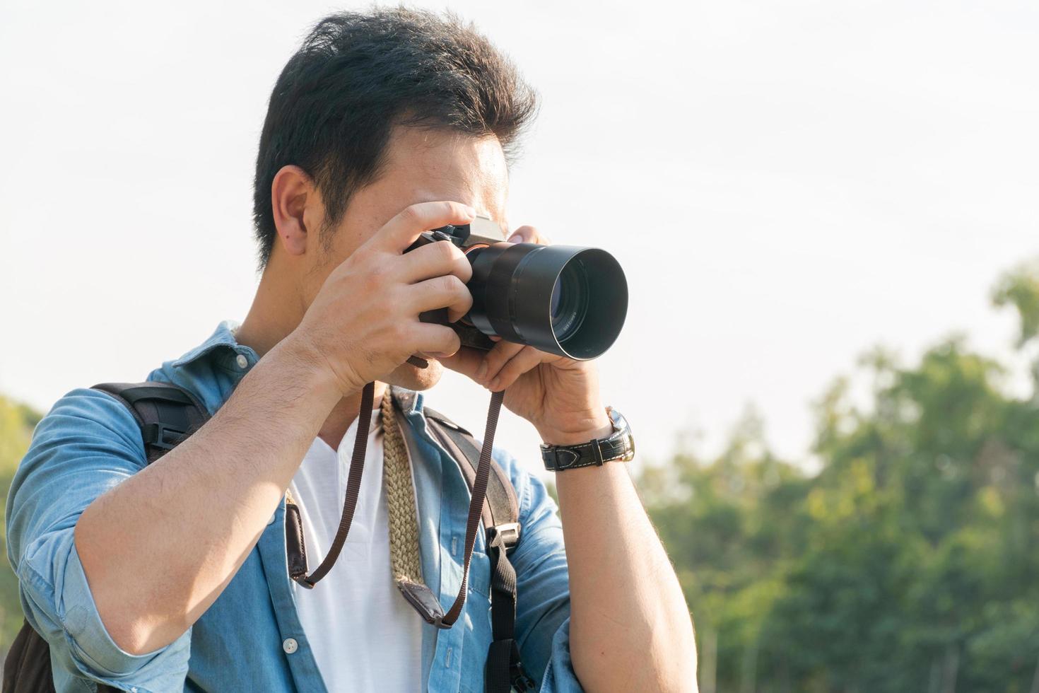 asiatisk man fotograf skytte landskap bild med kamera foto