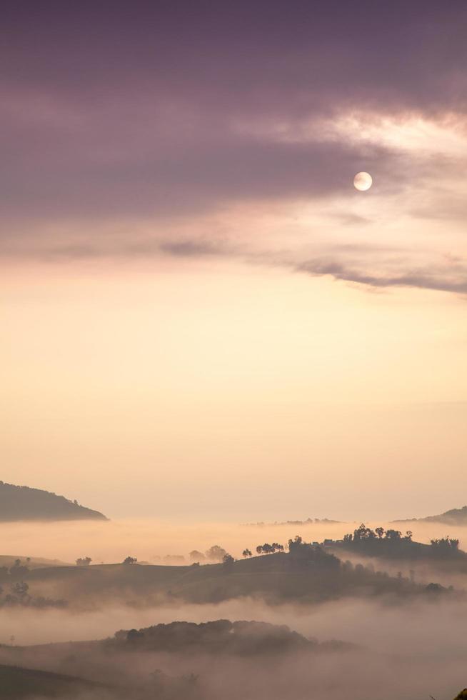 soluppgång och dimma över bergen foto