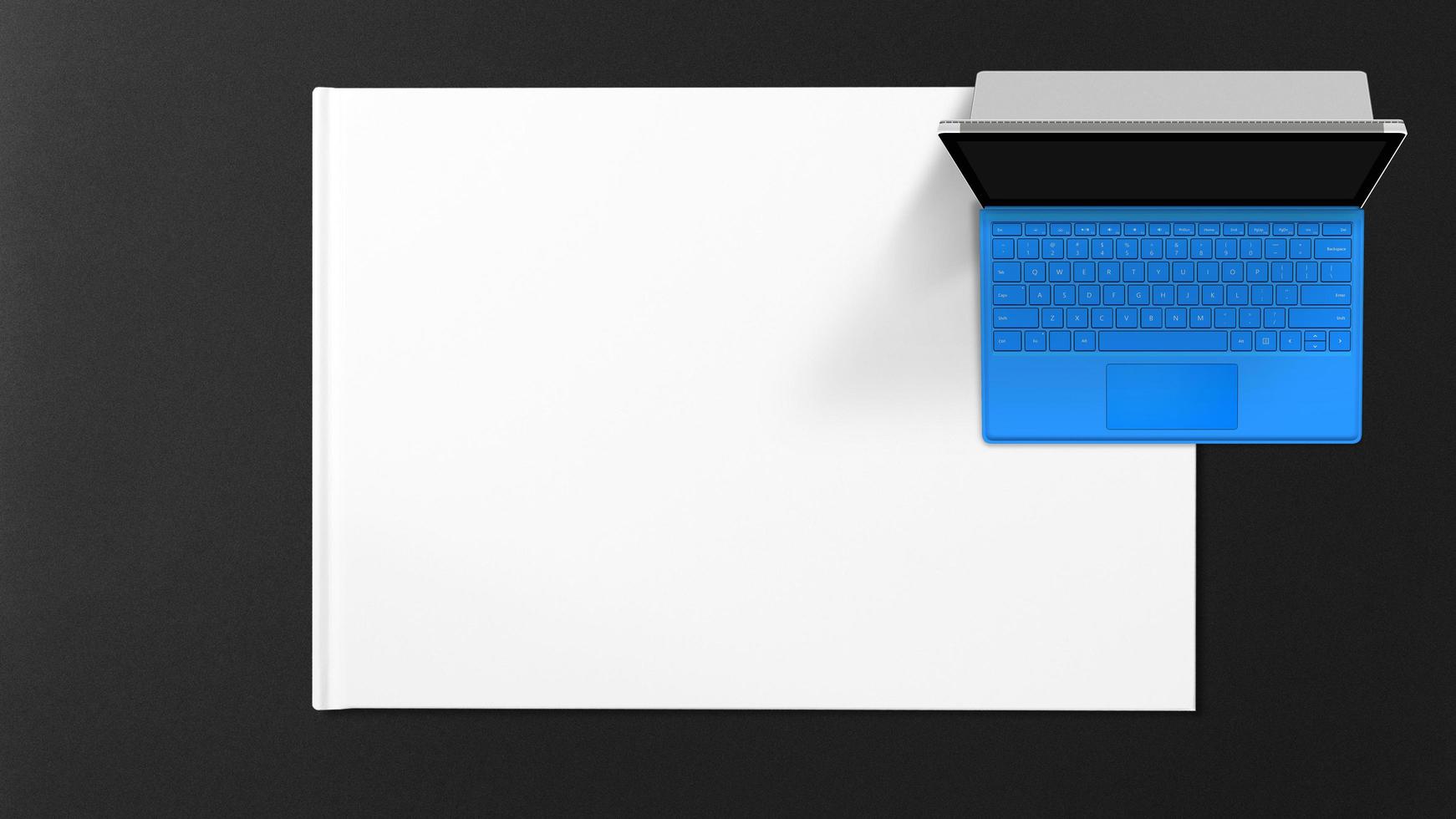 blå bärbar dator på vitbok på svart bakgrund foto
