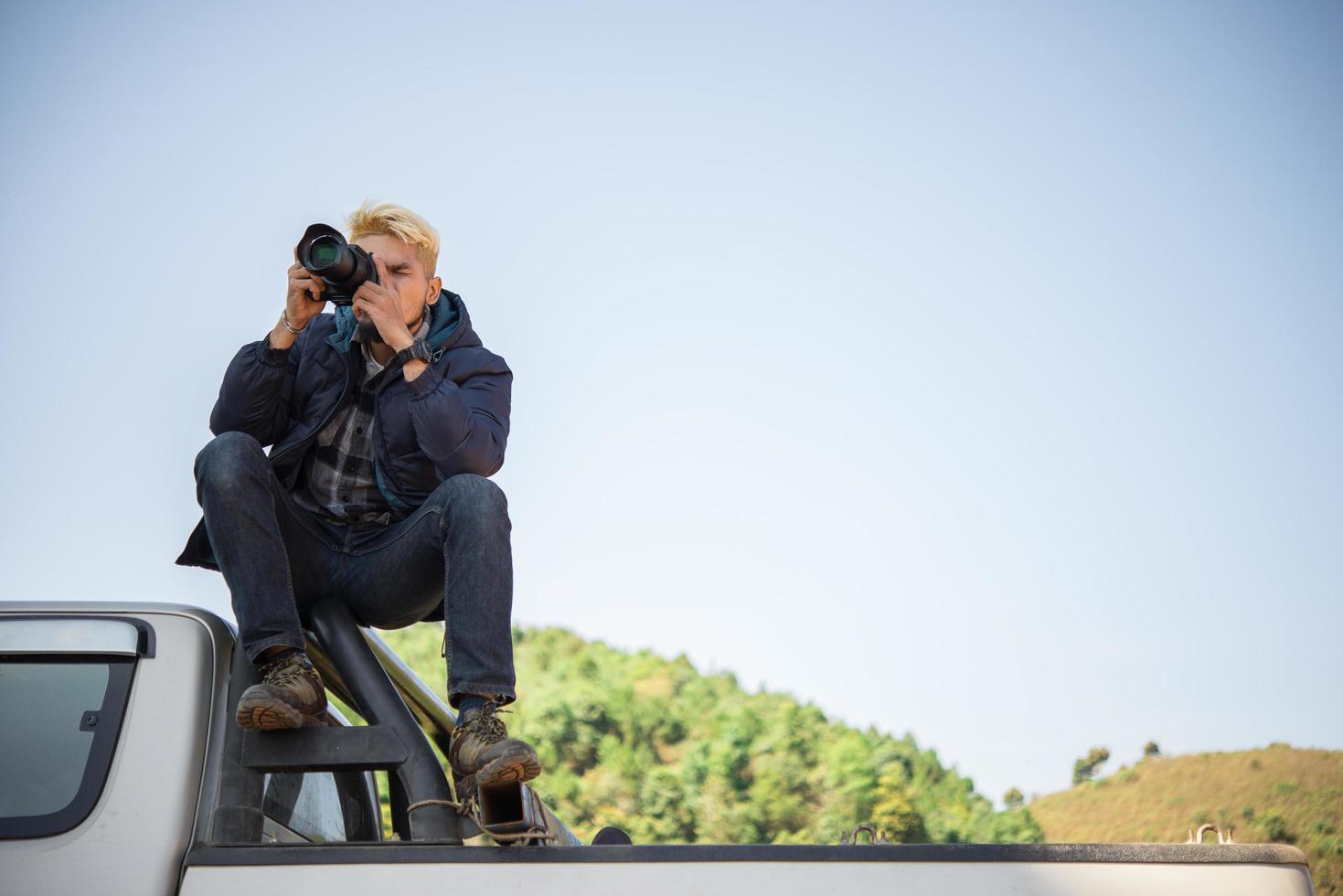 ung fotograf som sitter på sin pickup foto