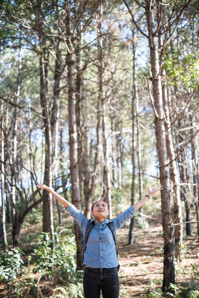 ung hipsterkvinna som njuter av naturen med utsträckta armar foto