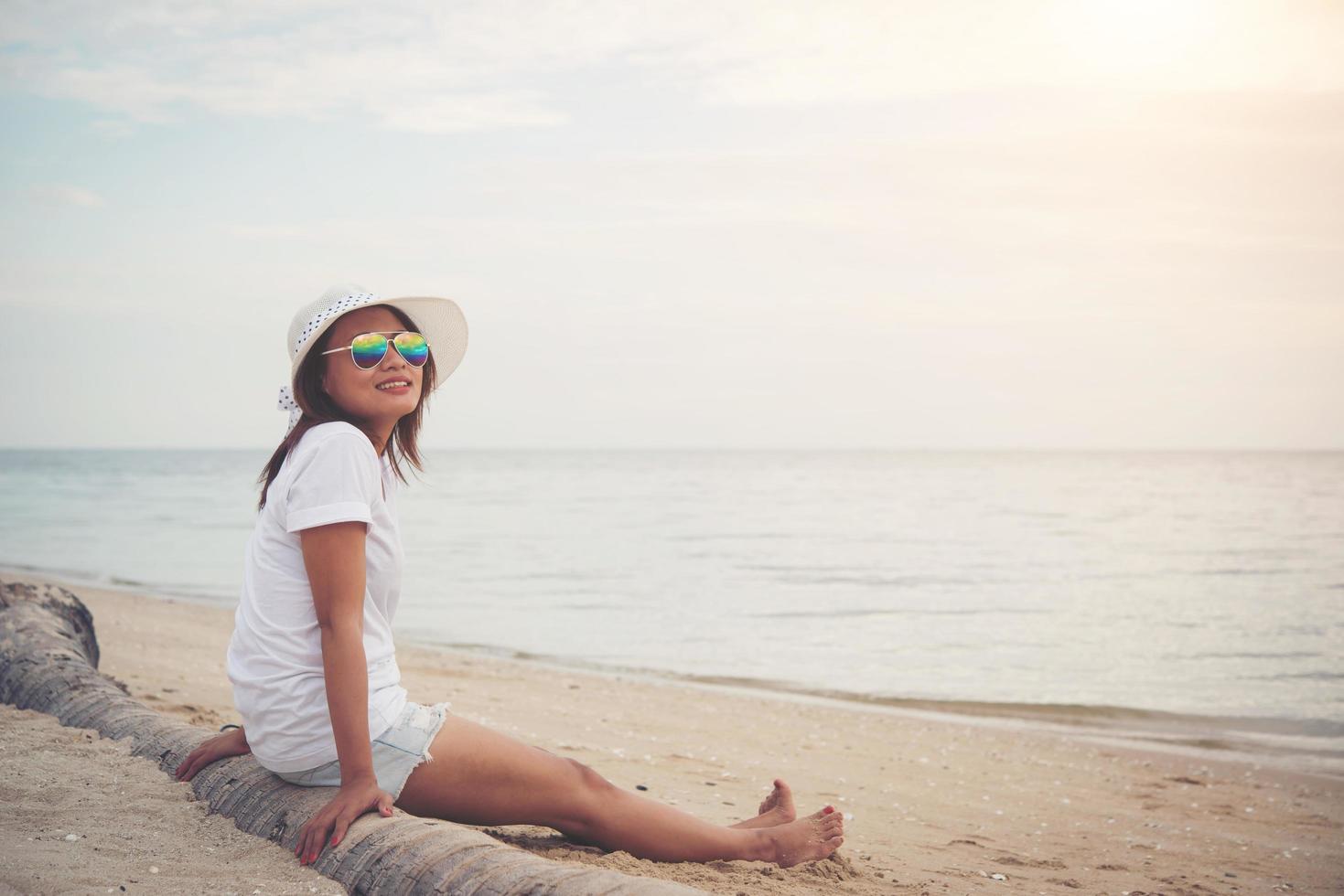 ung vacker kvinna som sitter på stranden foto