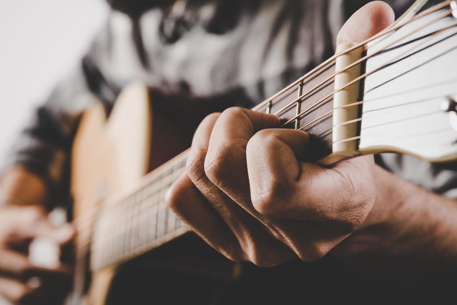 närbild av manhand som spelar gitarr foto