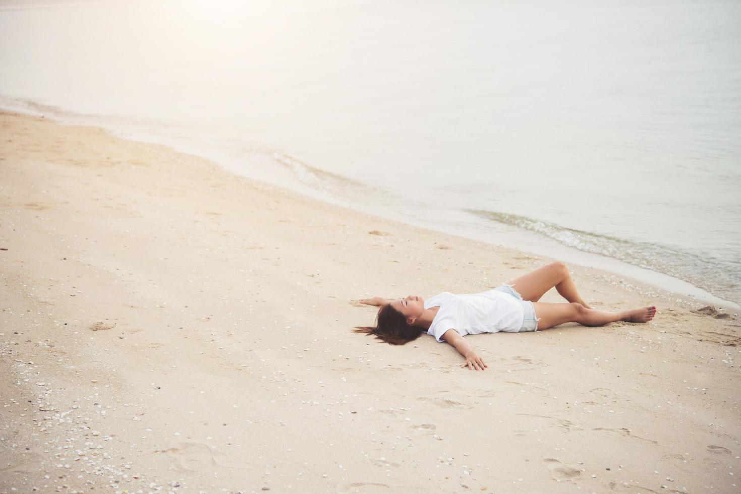 ung kvinna sitter på stranden foto