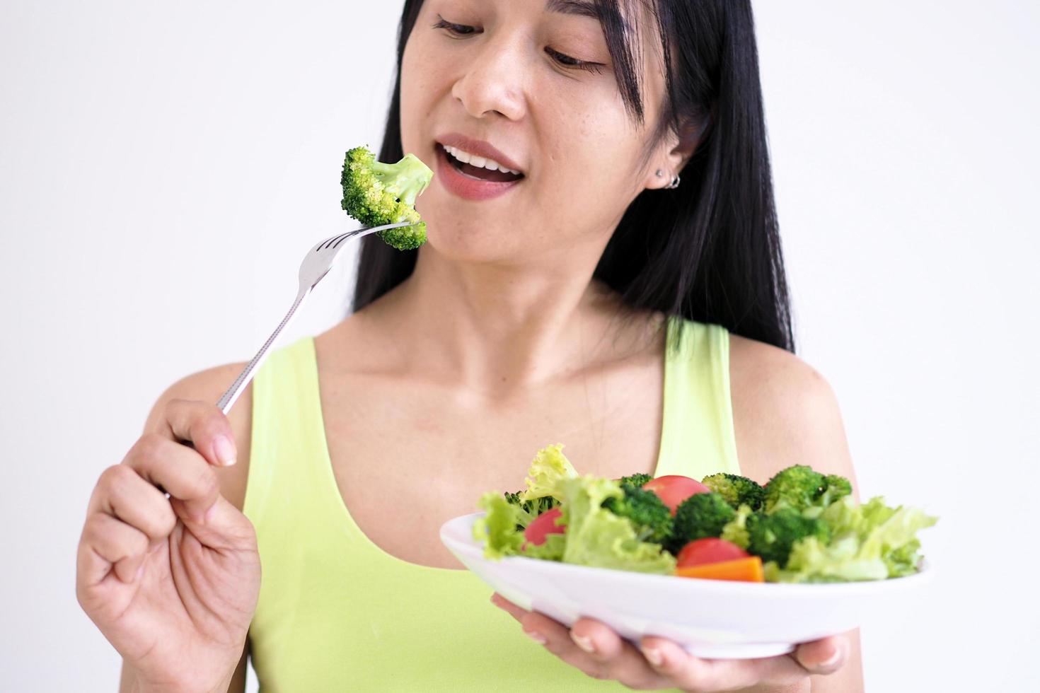 asiatisk skön kvinnor är Lycklig till äta sallad grönsaker. foto