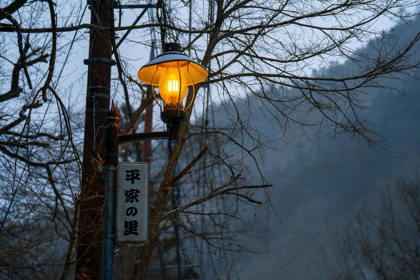 Nikko, japan - 26 januari 2023. volfram lampa och en japansk by tecken, tung snö täckt väg på heike Nej sato by i tochigi prefektur, nikko stad, foto