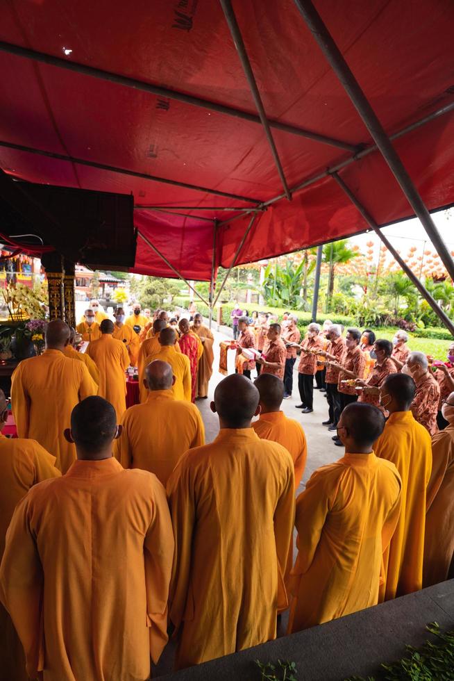 bandung, Indonesien, 2020 - de munkar i orange råna stående i beställa medan bön- till de Gud på de altare inuti de buddha tempel foto