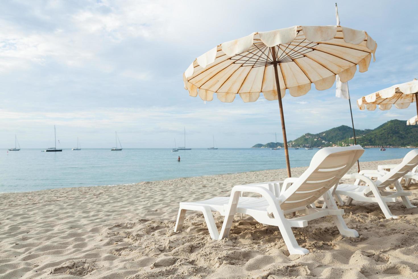 solstolar och parasoller på stranden foto