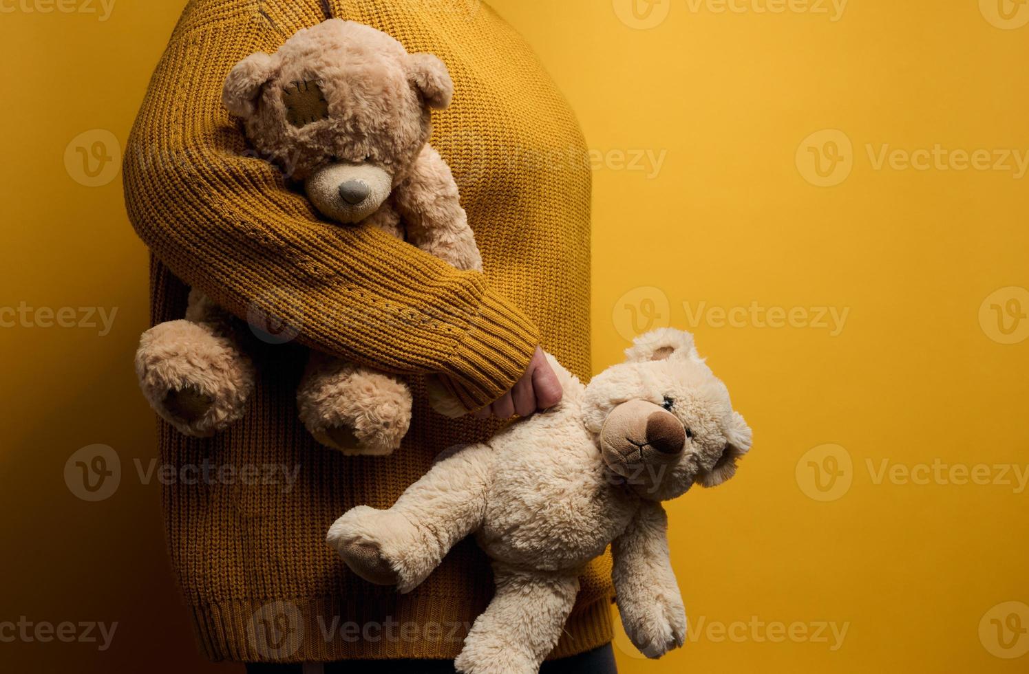 kvinna i orange stickat Tröja kramar söt brun teddy Björn. de begrepp av ensamhet och sorg, depression foto