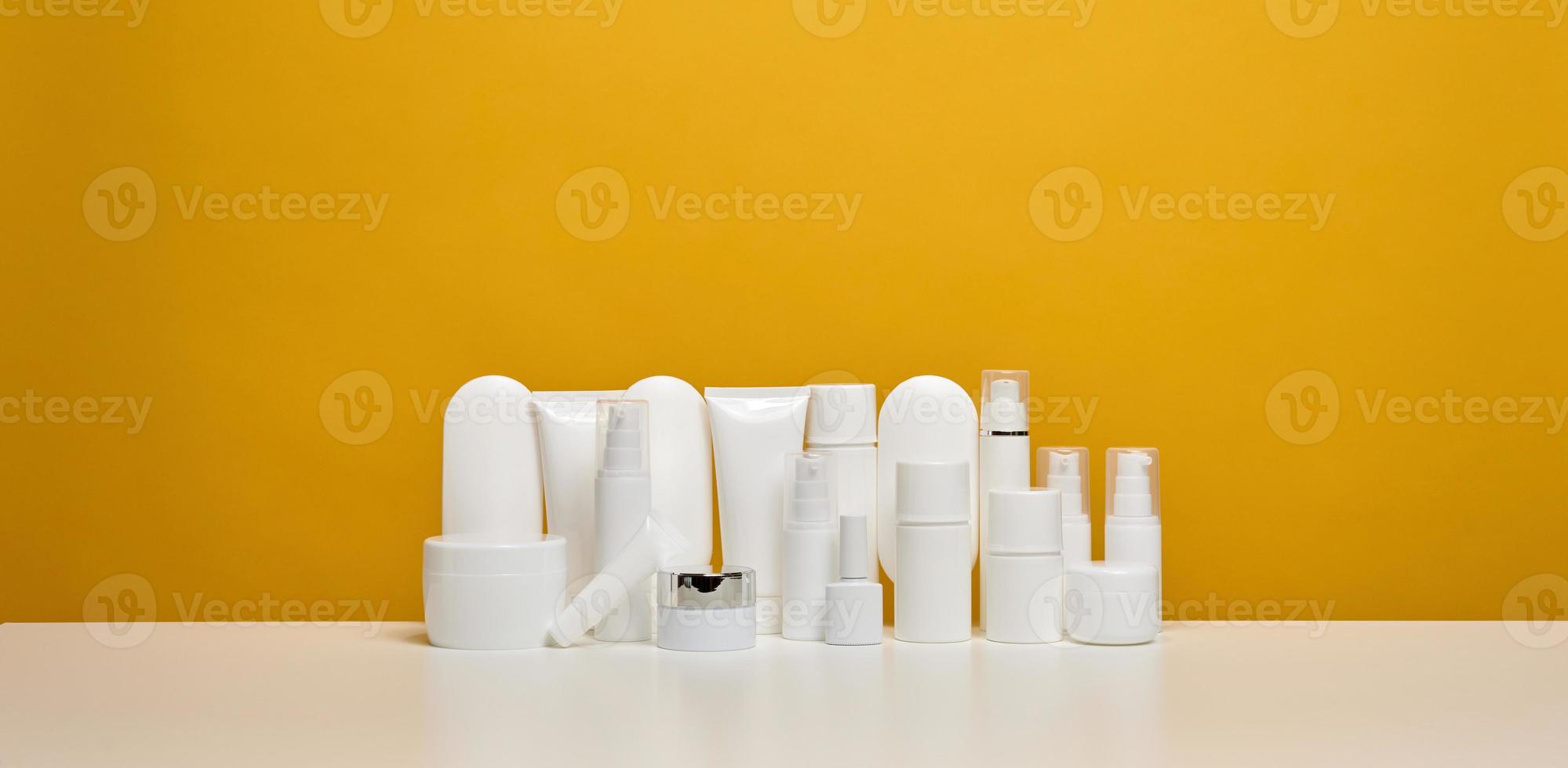 burk, flaska och tömma vit plast rör för kosmetika på en gul bakgrund. förpackning för grädde, gel, serum, reklam och produkt befordran foto