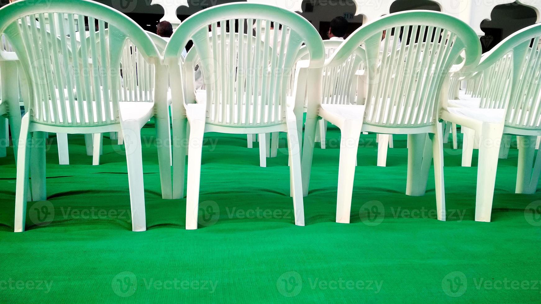 rader av tömma vit stolar väntar för de publik foto