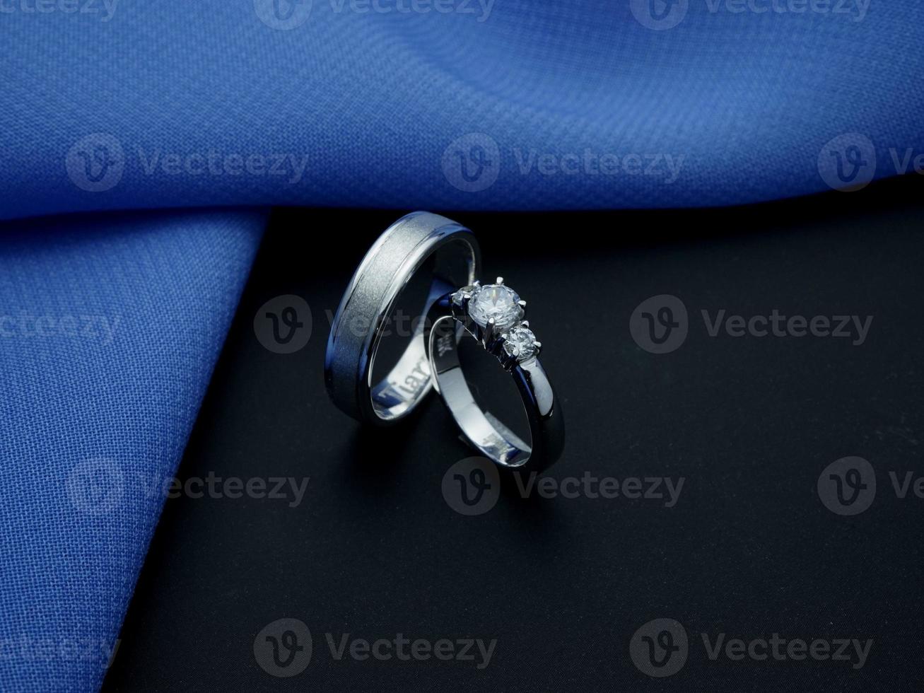 vit guld bröllop ringa. par ringa med glansig och doff efterbehandling med blå och svart bakgrund foto