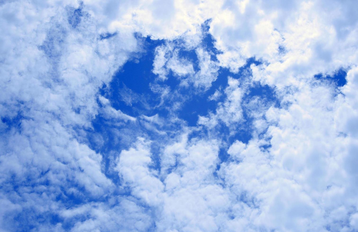 grupp av vita moln i en djupblå himmel foto