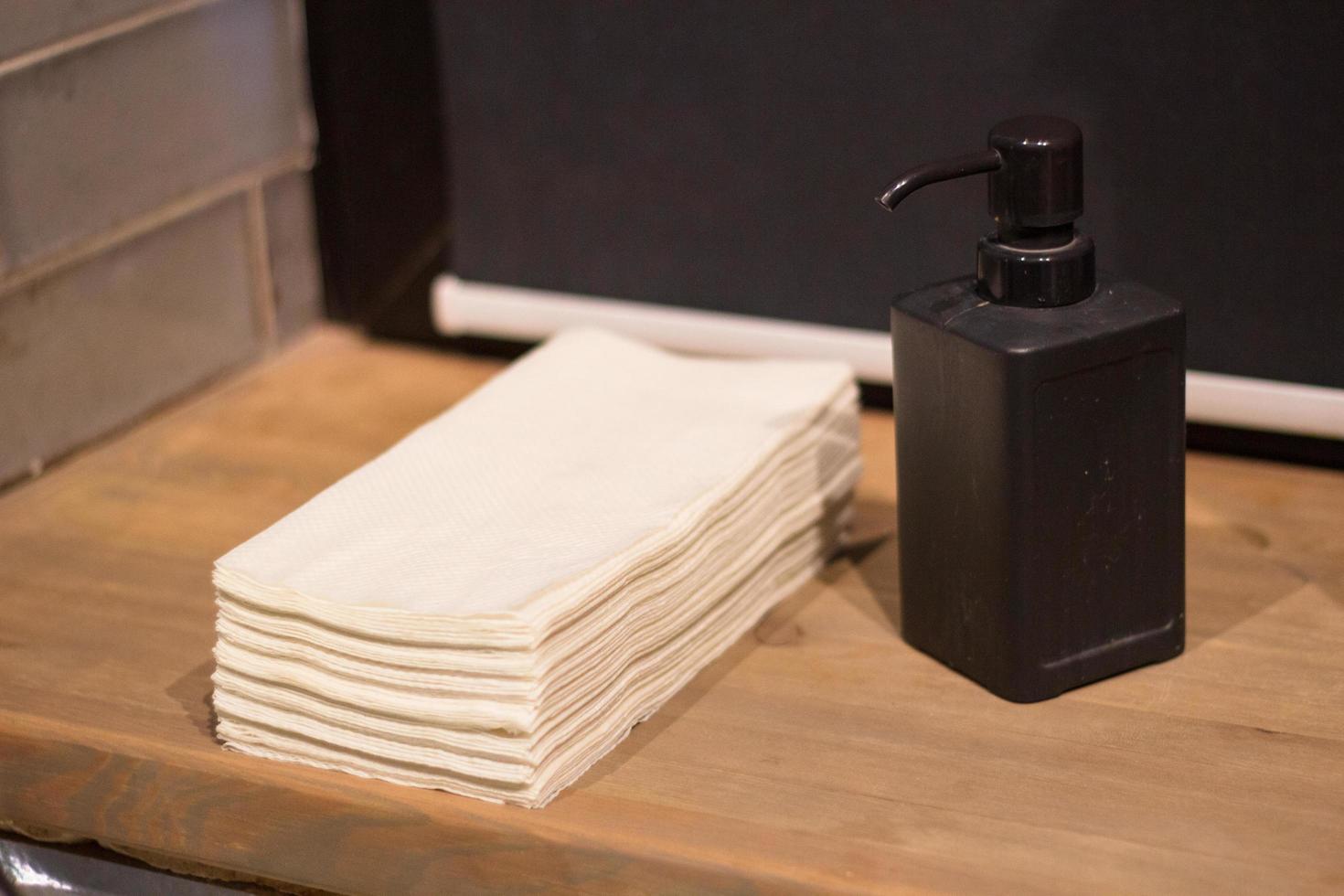 stack papper handdukar händer och flytande tvål dispenser foto